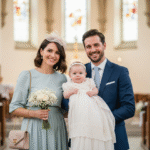 Rodzina w eleganckich strojach podczas chrztu w jasnym wnętrzu kościoła z dzieckiem w białej szacie