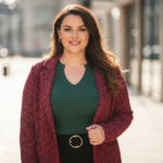 Pewna siebie kobieta plus size w modnym stroju, stojąca na tle miejskiego krajobrazu, uśmiechnięta i naturalna
