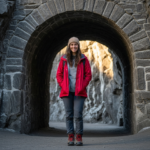 Kobieta ubrana na wycieczkę stoi przy wejściu do kopalni soli w Wieliczce na tle formacji solnych